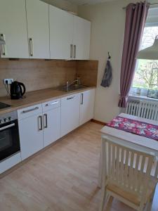 een keuken met witte kasten, een wastafel en een tafel bij Zur schönen Aussicht in Hameln