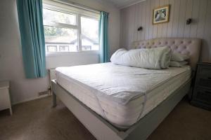 a bed in a bedroom with a window at Pet Friendly, Luxury Lodge With Decking In Suffolk Near The Beach Ref 32108a in Lowestoft