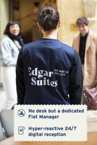 Um homem de camisa azul com um cartaz nas costas. em Edgar Suites Saint-Lazare - Amsterdam em Paris