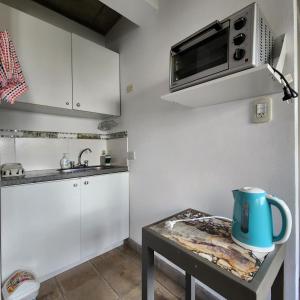 a small kitchen with a table and a microwave at CASA MARGARITA 1Piso Monoambiente in San Salvador de Jujuy
