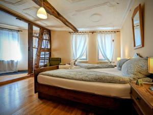 ein Schlafzimmer mit einem großen Bett in einem Zimmer mit Fenstern in der Unterkunft Gästehaus Pension Romantika in Cochem