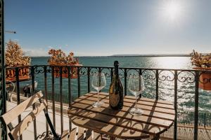 a table with two glasses and a bottle of wine on a balcony at Case vacanze vista mare in Siracusa