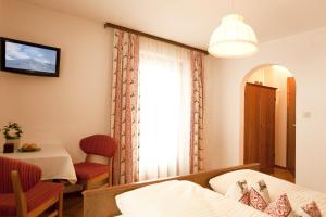 a room with a bed and a table and a window at Pension Anna in Sankt Leonhard im Pitztal