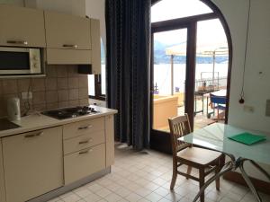 cocina con mesa y vistas al océano en Apartments Excelsior en Riva del Garda