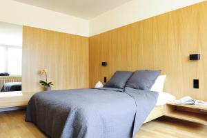 1 dormitorio con 1 cama grande y paredes de madera en Key Inn Appart Hotel Parc de Merl, en Luxemburgo