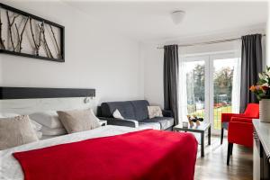 een slaapkamer met een rood bed en een rode bank bij Resort U Fořta in Hřensko +37 foto's
