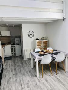 cocina y comedor con mesa y sillas en Appartement duplex lumineux idéalement situé, en Arès