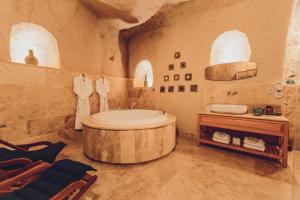 Habitación con techo y baño con bañera. en Peristyle Cave Cappadocia- Special Class, en Uchisar 115 fotos más