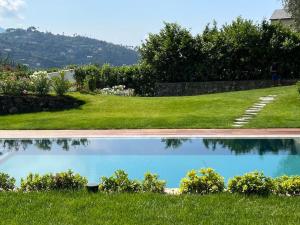 a pool of water in the grass next to a yard at Villa al Cio, Bonassola in Bonassola
