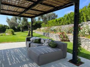 a couch sitting on a patio under a pergola at Villa al Cio, Bonassola in Bonassola