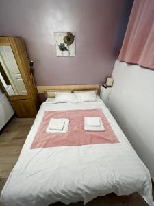 ein Schlafzimmer mit einem Bett mit zwei Handtüchern darauf in der Unterkunft Mira Duo Room in Braşov