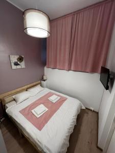 a small bedroom with a bed with two napkins on it at Mira Duo Room in Braşov