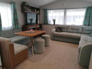 a living room with a couch and a table at Beautiful 8 Berth Caravan At Wild Duck Haven Park In Norfolk Ref 11195sc in Great Yarmouth