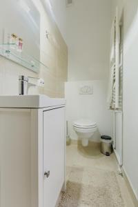 a white bathroom with a toilet and a sink at Mira Duo Room in Braşov