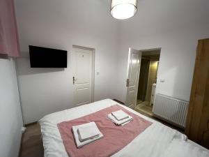 ein Schlafzimmer mit einem Bett mit zwei Handtüchern darauf in der Unterkunft Mira Duo Room in Braşov