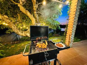 een grill met eten erop met een bord eten bij Căn Hộ Nghĩ Dưỡng Tuấn Hải - Nhà Chị Hai in Bao Loc