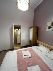 a bedroom with a large bed with two towels on it at Mira Duo Room in Braşov