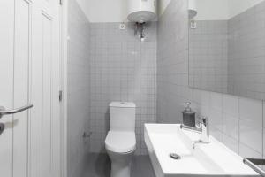 ein weißes Badezimmer mit Toilette und Waschbecken in der Unterkunft GuestReady - Costa Cabral Guesthouse in Porto + 190 Fotos