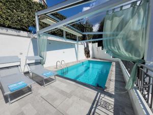 a swimming pool on a patio with two chairs and a table at Relais Cannavacciuolo in Vico Equense