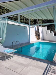 a blue swimming pool with a pergola next to a swimming pool at Relais Cannavacciuolo in Vico Equense +23 photos