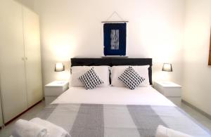 a bedroom with a large white bed with two night stands at Marina Bay - Castelsardo in Castelsardo
