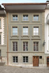 a large building with many windows on a street at La Sauvage in Fribourg