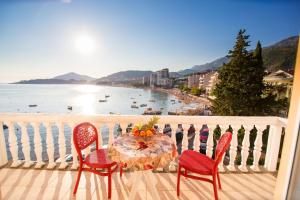 un tavolo e sedie su un balcone con vista sull'acqua di ACIKA apartments a Rafailovici