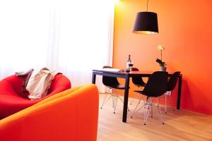 a living room with a table and a red couch at Key Inn Appart Hotel Parc de Merl in Luxembourg