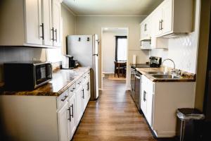 a kitchen with white cabinets and a refrigerator at Urban Cottage: Homey & Convenient in Huntington