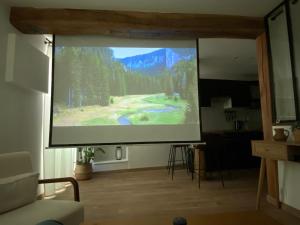 a large screen in a living room with a presentation at Grand T1 Allevard centre in Allevard