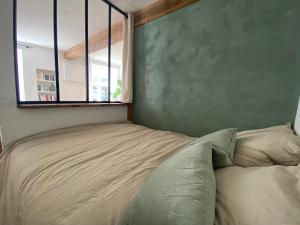 um quarto com uma cama com uma janela em Grand T1 Allevard centre em Allevard