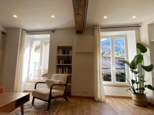 a living room with a chair and two windows at Grand T1 Allevard centre in Allevard