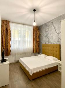 ein Schlafzimmer mit einem Bett und einem großen Fenster in der Unterkunft Tanya Apartments Nord10 in Mamaia Nord – Năvodari