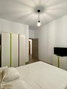 ein Schlafzimmer mit einem weißen Bett und einer Decke in der Unterkunft Tanya Apartments Nord10 in Mamaia Nord – Năvodari