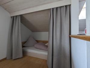 a bed in a room with a curtain in a attic at Ferienwohnung Murnauer Moos in Murnau am Staffelsee