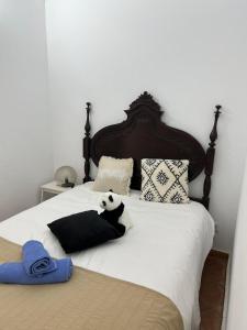 a bed with a stuffed panda bear sitting on it at CASA BLUE NOTE in Olhão +22 photos