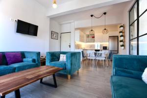 ein Wohnzimmer mit blauen Stühlen und einem Tisch in der Unterkunft GK Grand Comfort in Athen