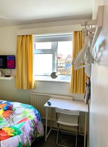 a bedroom with a bed and a desk and a window at The Old Barn Little Wing in Amersham