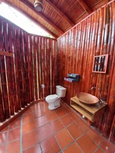 a bathroom with a toilet and a wooden wall at La Bota del Gigante in Gigante