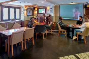 um grupo de pessoas sentadas em mesas em um restaurante em Holiday Inn London Bloomsbury, an IHG Hotel em Londres