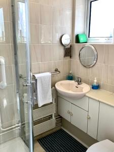 a bathroom with a shower and a sink and a mirror at The Old Barn Little Wing in Amersham