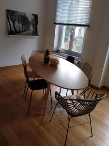 een eettafel en stoelen in een kamer met een tafel bij 'Nulle Part Ailleurs' in Dinant