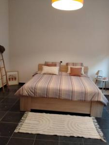 een bed met een gestreept dekbed in een slaapkamer bij 'Nulle Part Ailleurs' in Dinant