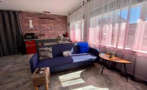 a living room with a blue couch and a table at Dalgety Bay Luxury Studio Apartment in Saint Davids