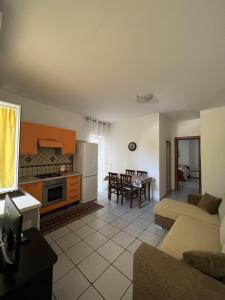 eine Küche und ein Wohnzimmer mit einem Sofa und einem Tisch in der Unterkunft Casa D'Ambra in Ischia