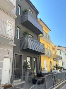 an apartment building with a balcony with plants on it at Appartamenti Mar y Sol in Gabicce Mare