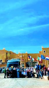 a group of people standing in front of a van at Kasbah Citoyenne in Agoudal