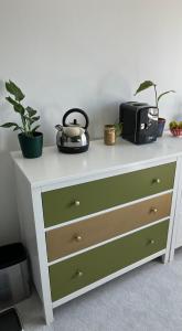 a white and green dresser with plants on top of it at Sevenoaks Centre Hideaway in Sevenoaks