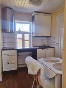 a kitchen with white cabinets and a white sink at Villa Marienholm in Haapsalu