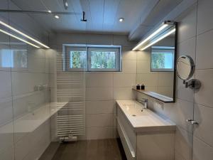 a white bathroom with two sinks and a mirror at Apartments Hohenberger in Mallnitz